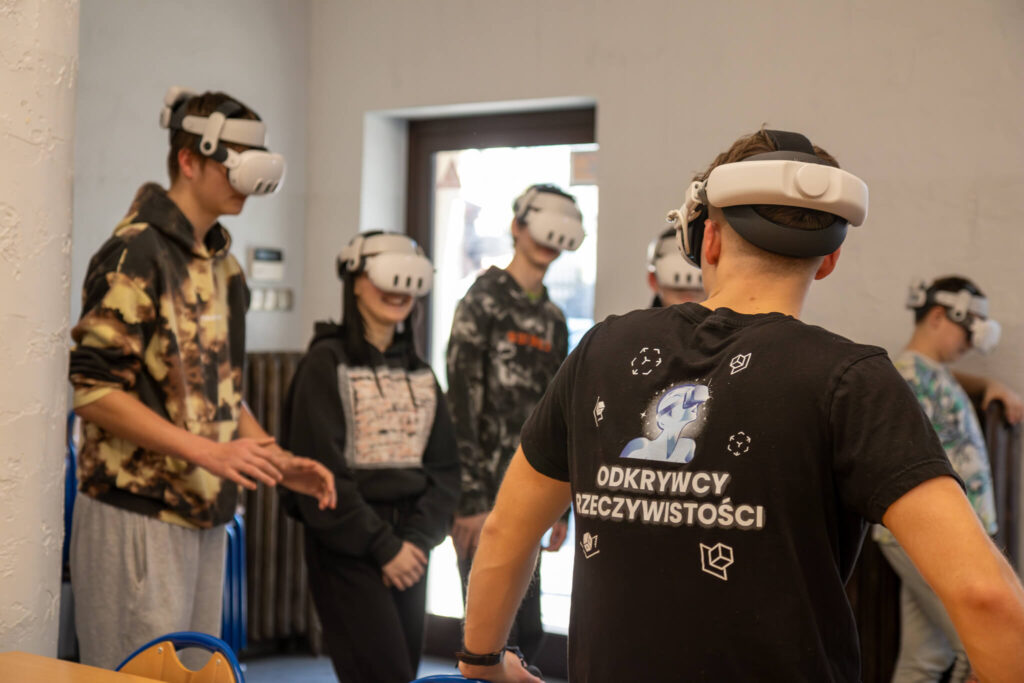 parę osób z goglami VR na głowach, uczestniczą w lekcji VR