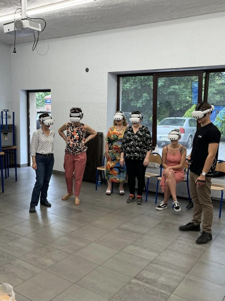A group of participants wearing VR headsets in a workshop room at the ESTEDE Scena To Dziwna Cultural Centre