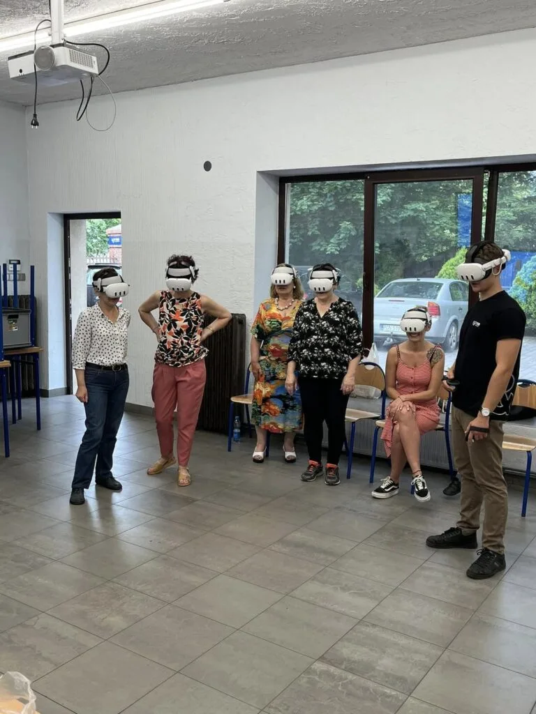Grupa uczestników w goglach VR w sali warsztatowej w centrum kultury ESTEDE Scena To Dziwna