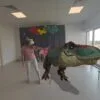 Dziewczynka w goglach VR wyciąga rękę w stronę wirtualnego dinozaura w Gnieźnieńskim Ośrodku Sportu i Rekreacji