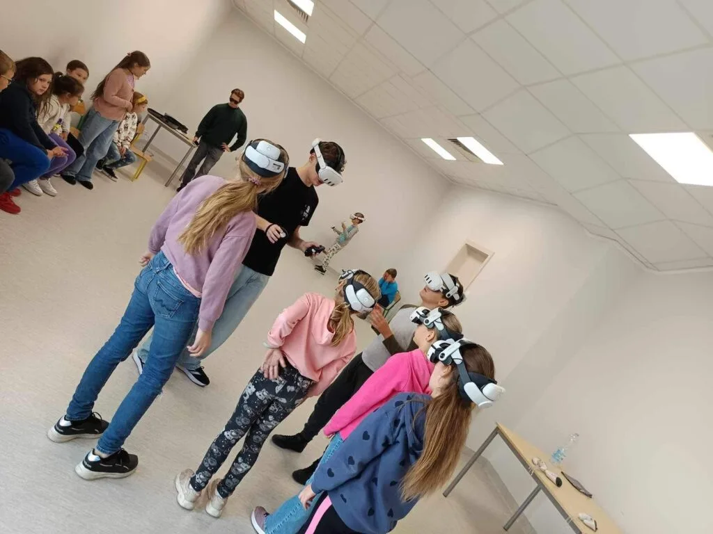 Rząd uczniów w goglach VR podczas wspólnego zadania w wirtualnej rzeczywistości w Gnieźnieńskim Ośrodku Sportu i Rekreacji