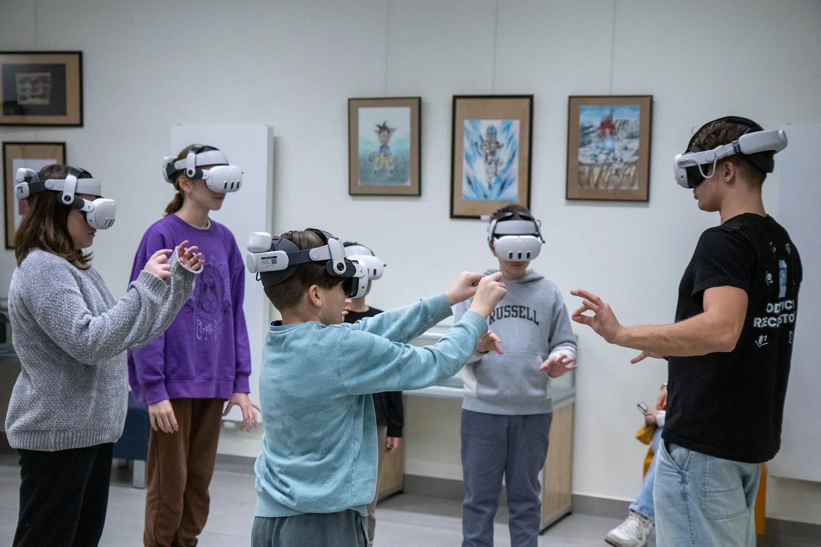 Troje dzieci w goglach VR sięga rękami po wirtualne obiekty na lekcji historii w Prywatnej Szkole Podstawowej Harmonia Jeżyce