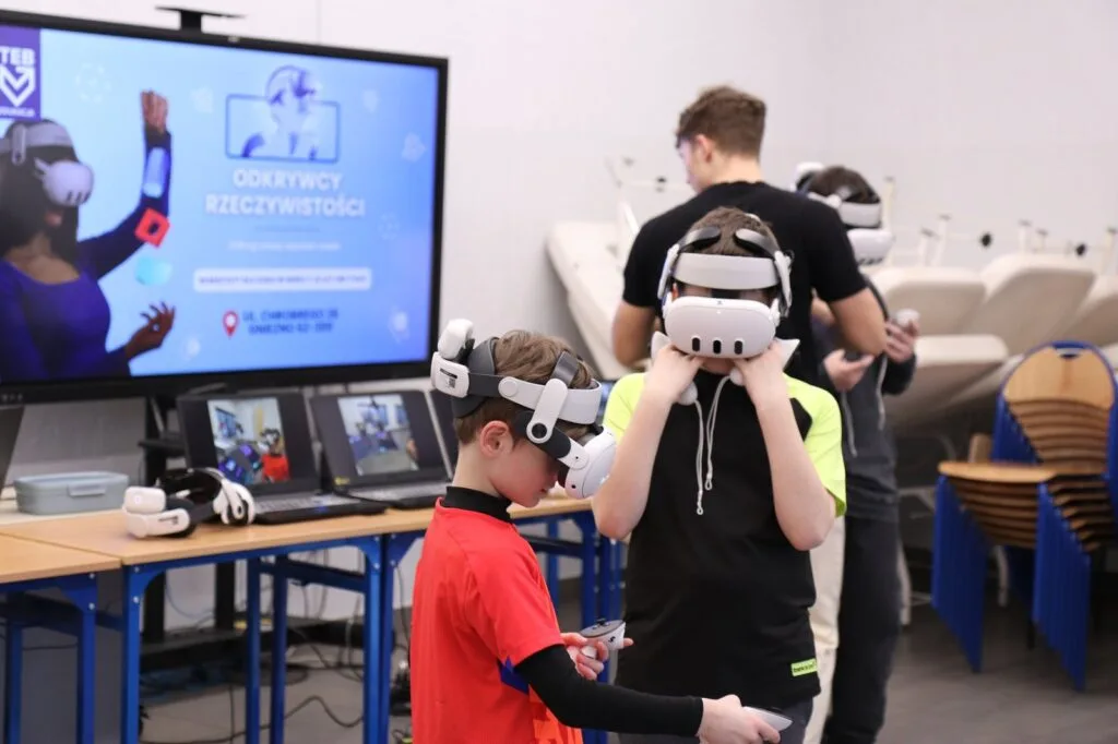 Dzieci w goglach VR przed ekranem z planszą warsztatów Zenith XR w Szkole Podstawowej Olimpus w Gutowie Małym
