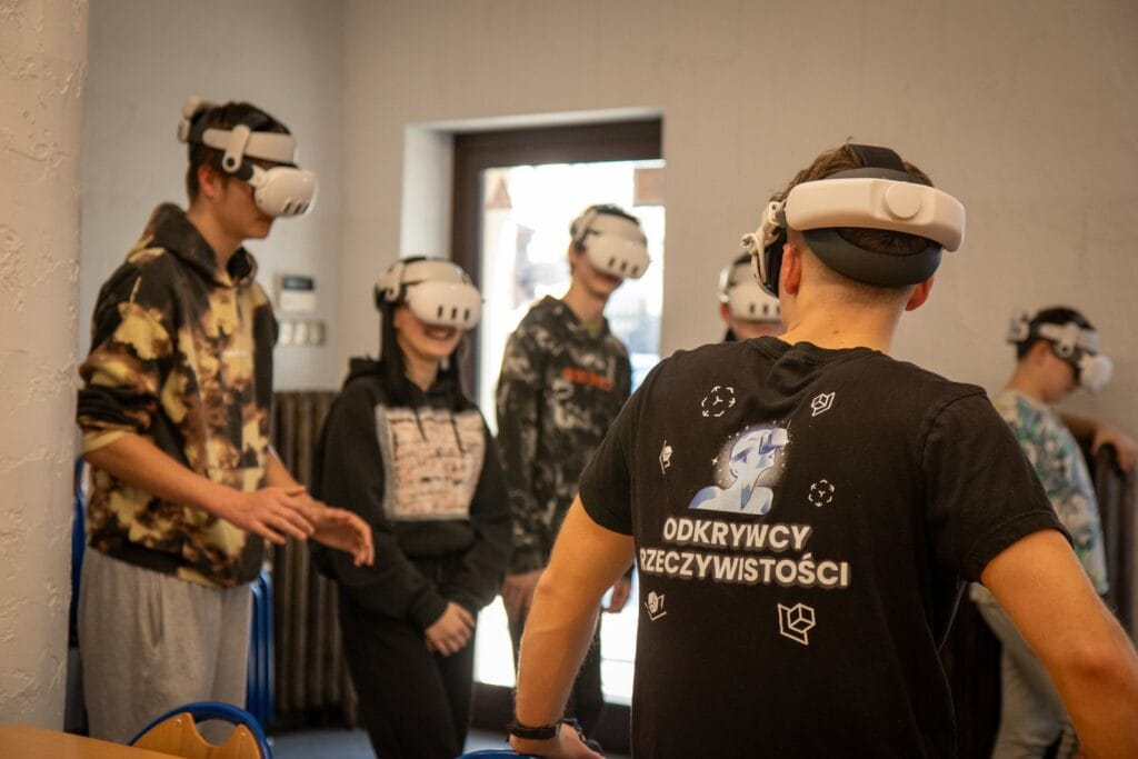Grupa uczniów w goglach VR i prowadzący warsztaty Zenith XR w Psarach Polskich