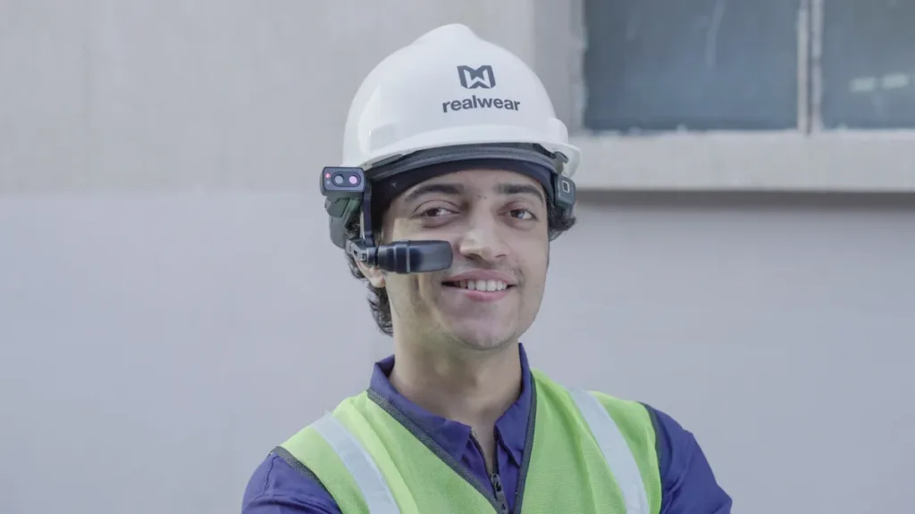 Worker in a hard hat and high-visibility clothing using a RealWear Navigator 520