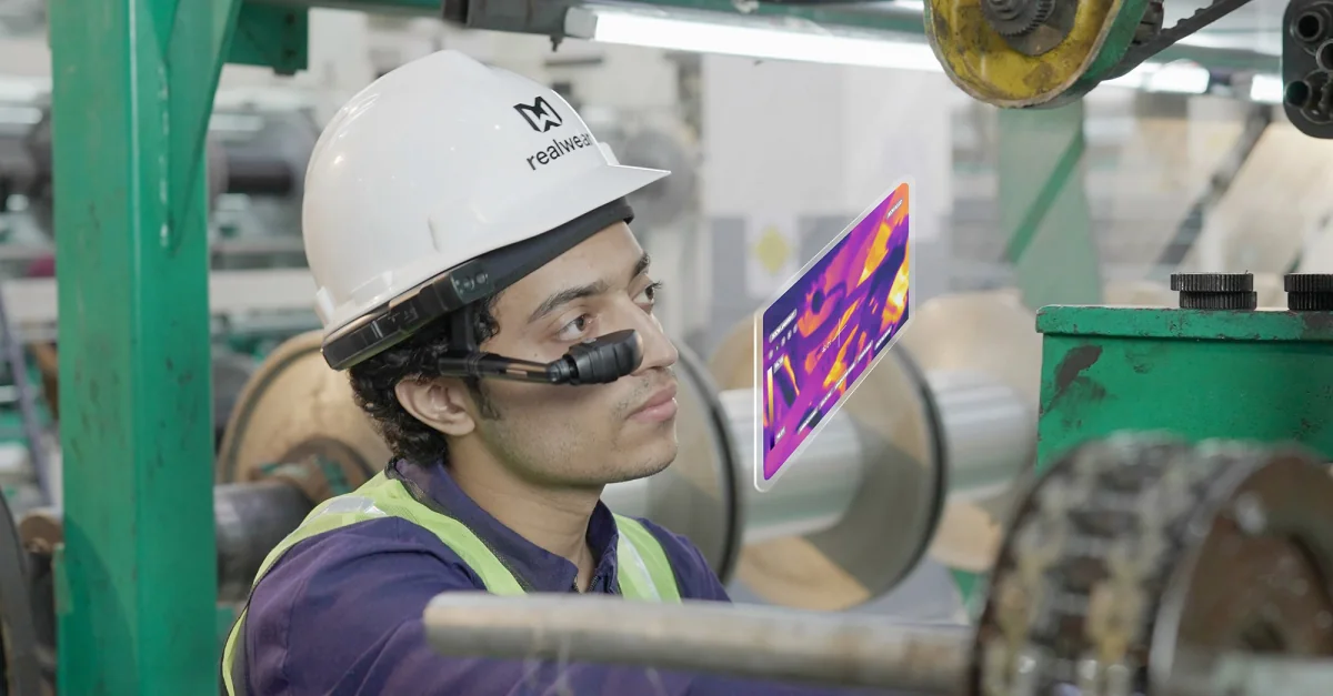 A worker at an industrial installation wearing RealWear, with an example thermal image
