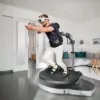 Man using a Virtuix Omni One VR treadmill in a room