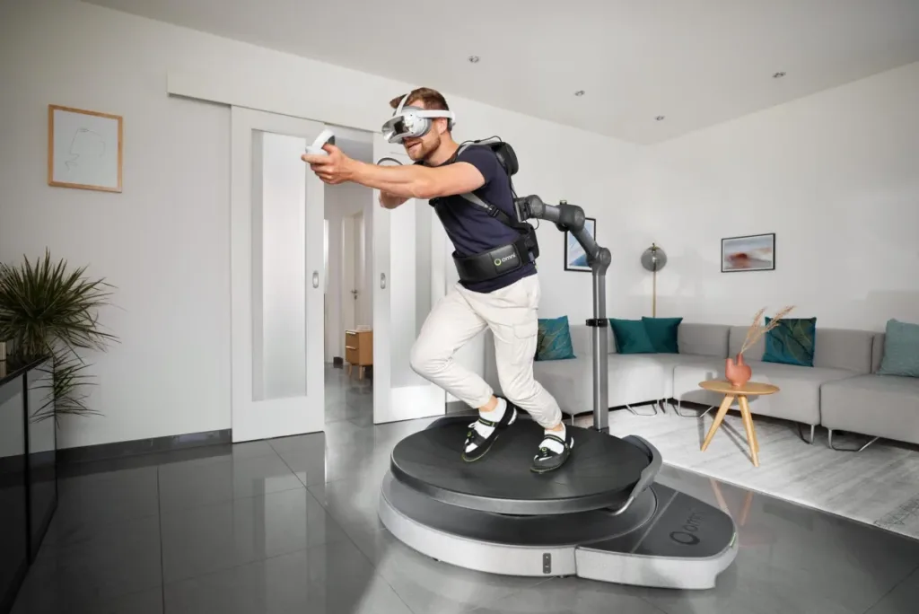 Man using a Virtuix Omni One VR treadmill in a room