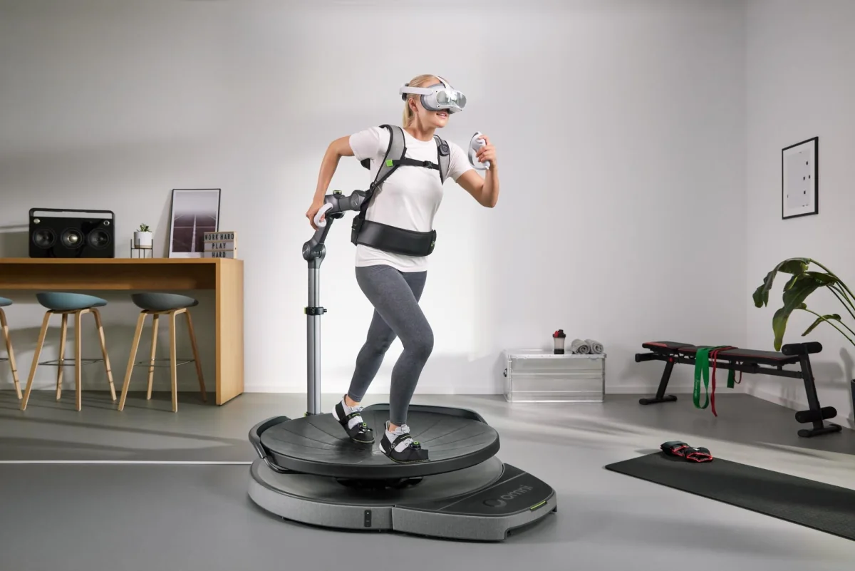 A woman using a Virtuix Omni One VR treadmill in a living room
