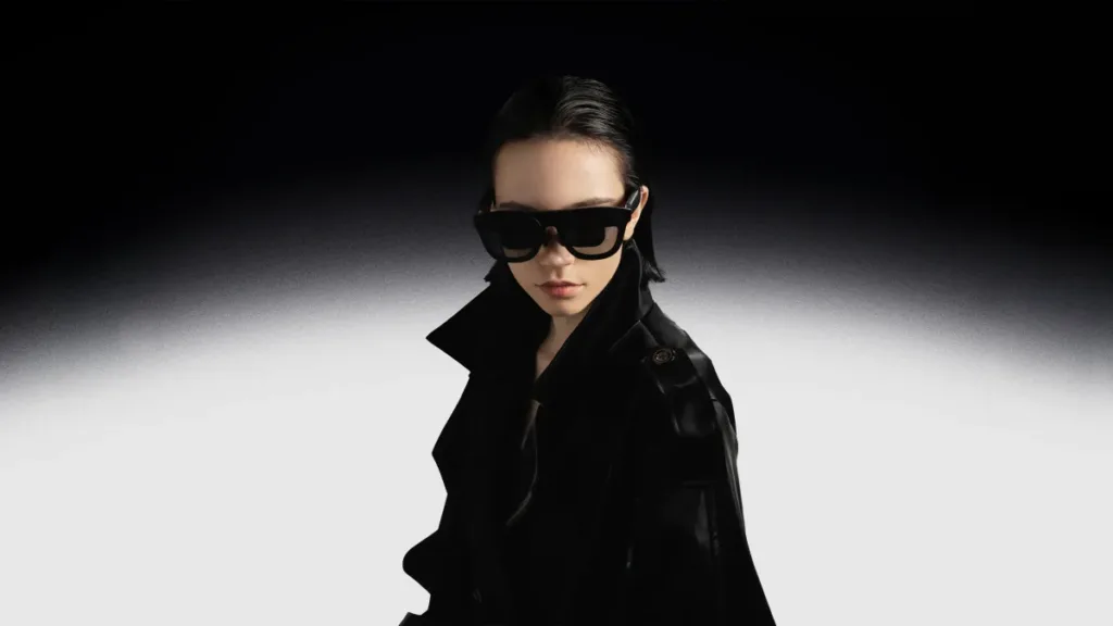 A woman wearing black XREAL One Pro glasses